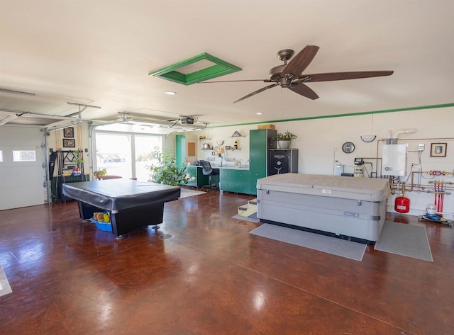 recreation room featuring a garage, ceiling fan, water heater, and concrete flooring