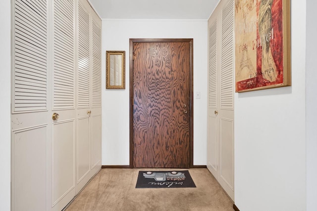 entryway featuring light carpet and baseboards