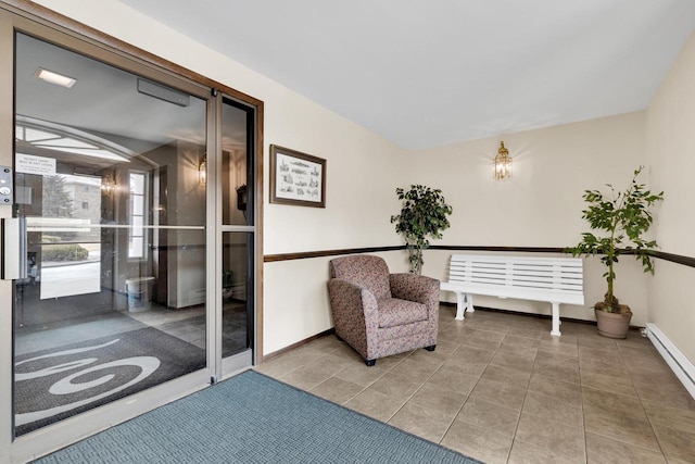 sitting room featuring a baseboard radiator, baseboards, and tile patterned floors