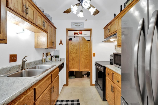 kitchen featuring stainless steel appliances, light countertops, a sink, and under cabinet range hood