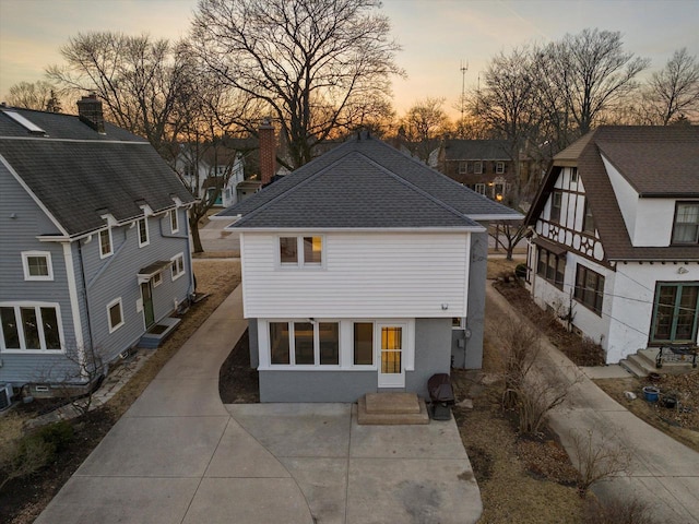 view of front of house featuring stucco siding, a shingled roof, and entry steps