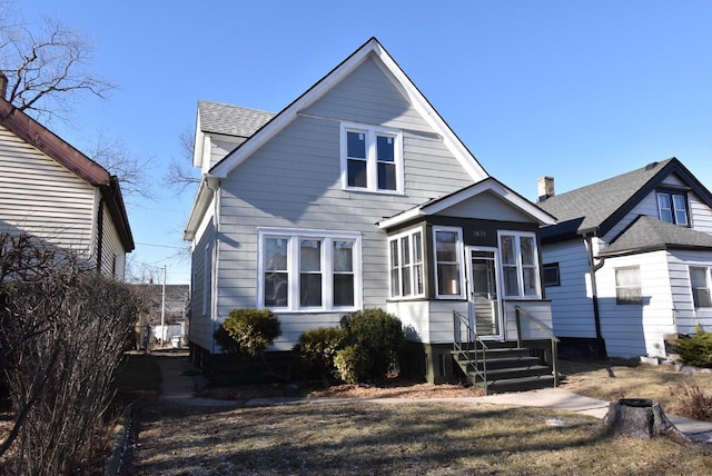 view of front facade featuring a sunroom and roof with shingles