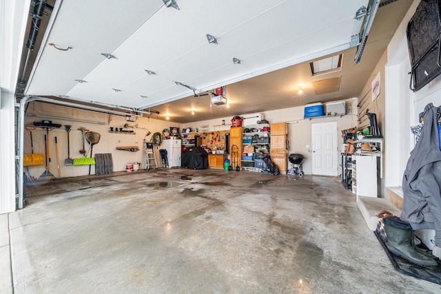 garage featuring a garage door opener and a workshop area