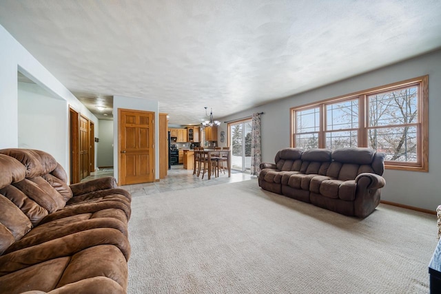 living area with a chandelier, light carpet, and baseboards