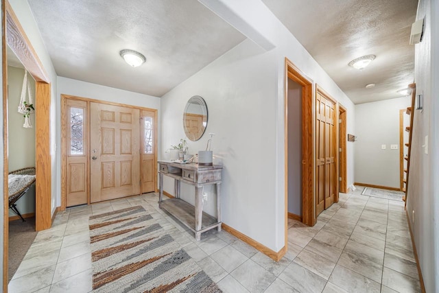 entryway with a textured ceiling and baseboards