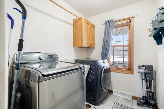 clothes washing area featuring cabinet space, baseboards, visible vents, and independent washer and dryer