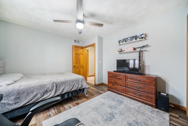 bedroom with visible vents, baseboards, and wood finished floors