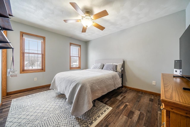 bedroom with dark wood-style floors, ceiling fan, and baseboards