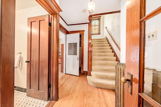 interior space with stairs, ornamental molding, and light wood-style flooring