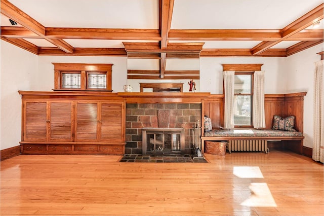 unfurnished living room with a fireplace with flush hearth, coffered ceiling, and wood finished floors