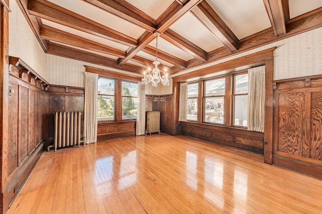 unfurnished living room featuring radiator, hardwood / wood-style floors, and wallpapered walls