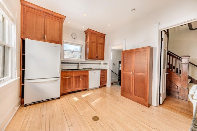 kitchen featuring light wood-style flooring, recessed lighting, white appliances, decorative backsplash, and brown cabinetry