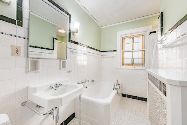 full bath with toilet, tile patterned flooring, a garden tub, and tile walls