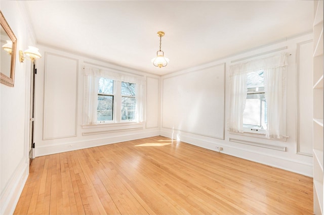 empty room featuring hardwood / wood-style floors and a decorative wall