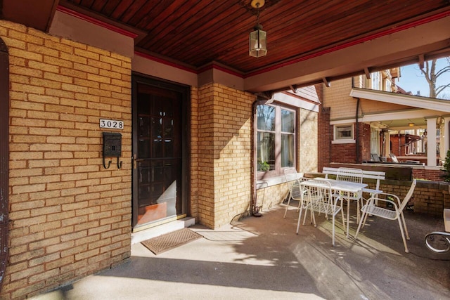 entrance to property featuring outdoor dining space and brick siding