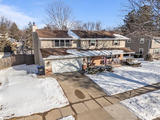 view of front of property featuring an attached garage, brick siding, fence, concrete driveway, and a chimney