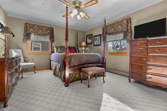 bedroom with ceiling fan, a baseboard radiator, light colored carpet, and baseboards