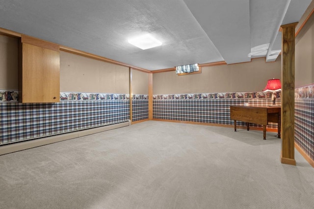 basement with wallpapered walls, wainscoting, baseboard heating, a textured ceiling, and carpet floors