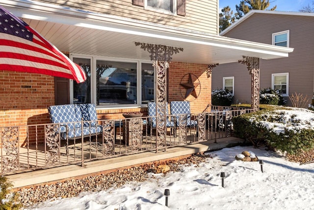 snow covered patio featuring a porch