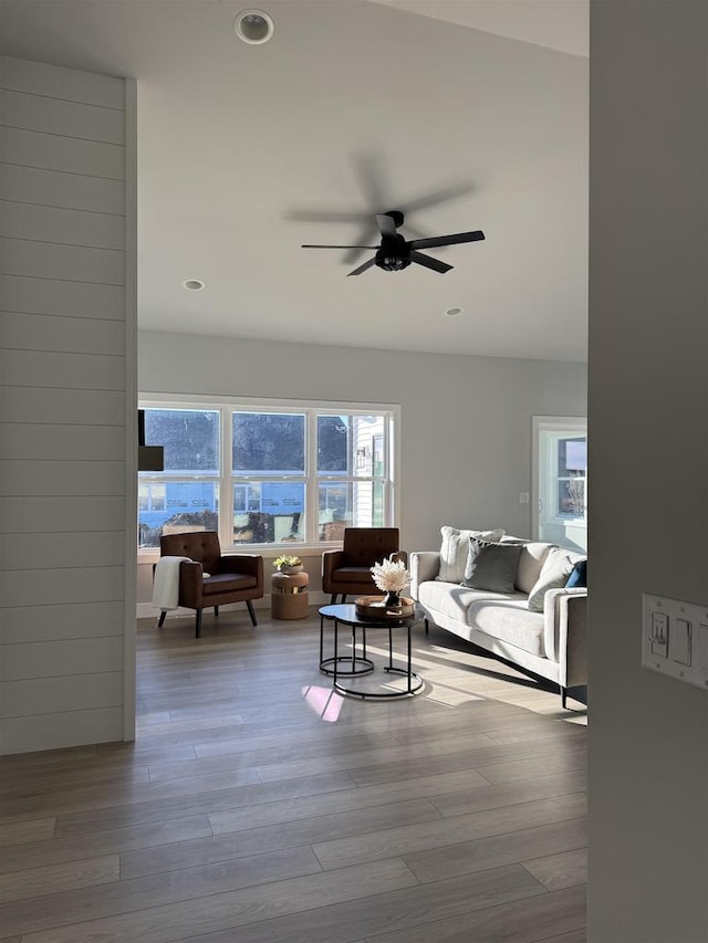 living room with a ceiling fan, recessed lighting, and wood finished floors