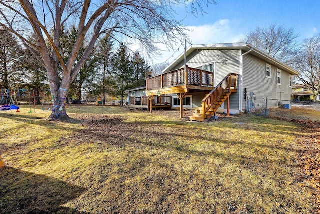 back of house featuring stairway, a wooden deck, a yard, and fence