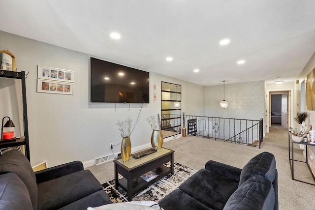 carpeted living area with recessed lighting, visible vents, and baseboards