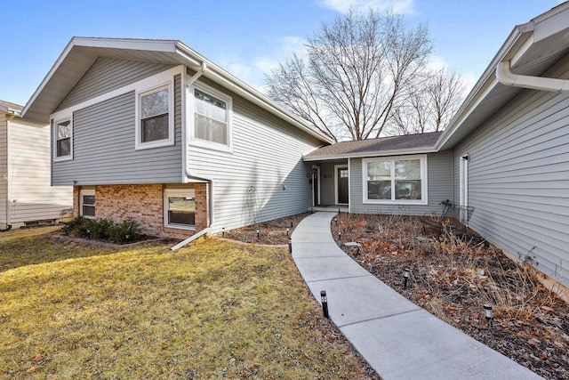 property entrance with brick siding and a lawn