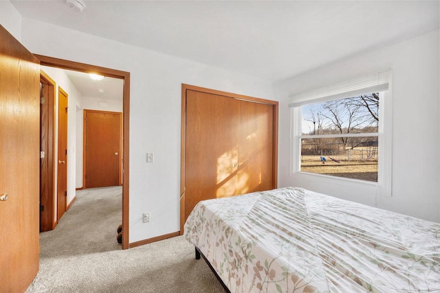 carpeted bedroom with baseboards and a closet