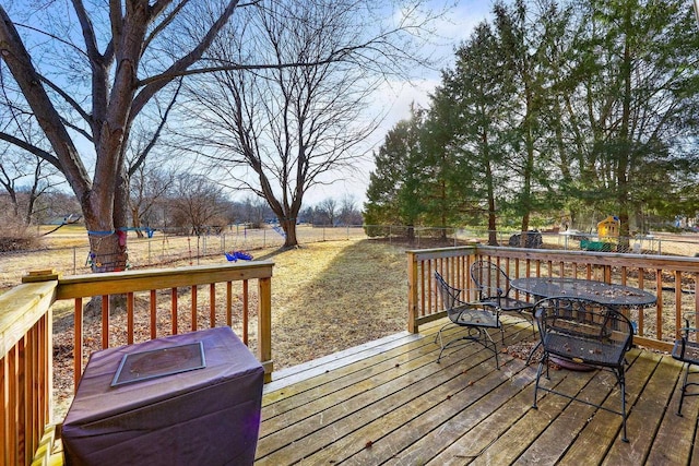 wooden deck with a fenced backyard and outdoor dining space