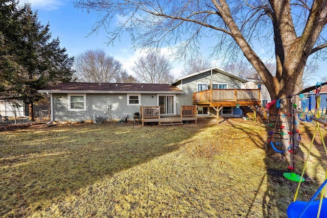 back of house featuring a lawn, a deck, fence, a playground, and central AC unit