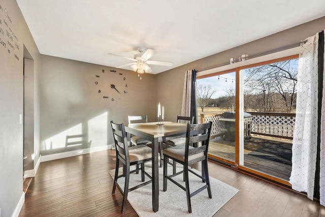 dining room featuring ceiling fan, baseboards, and wood finished floors