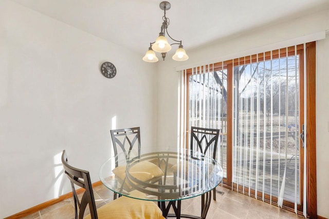 dining area featuring tile patterned flooring, an inviting chandelier, and baseboards