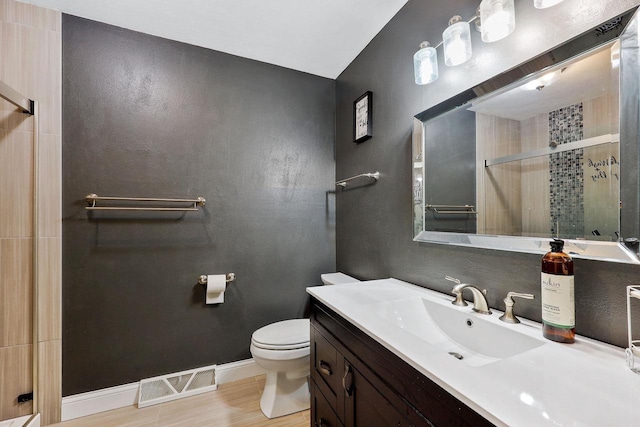 bathroom featuring vanity, baseboards, visible vents, a stall shower, and toilet