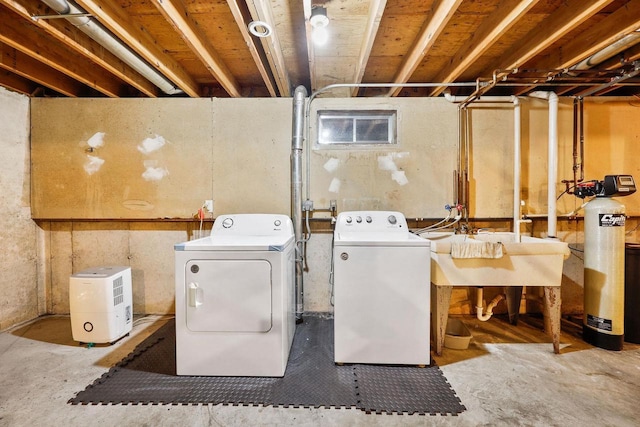 washroom with laundry area, a sink, and separate washer and dryer