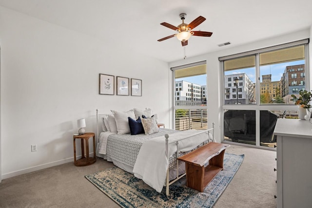 bedroom with baseboards, visible vents, access to outside, a view of city, and carpet floors