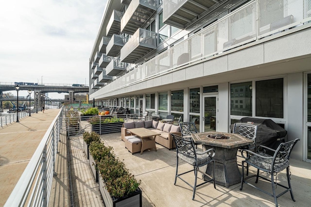 view of patio featuring a water view, an outdoor living space with a fire pit, and area for grilling