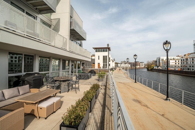 view of property's community with an outdoor fire pit and a water view