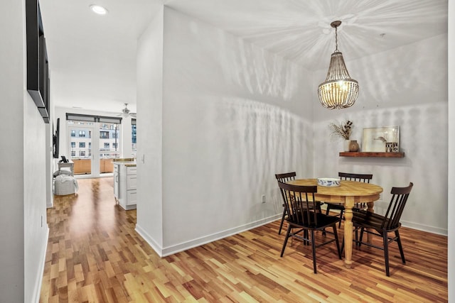 dining room with recessed lighting, light wood-style flooring, baseboards, and ceiling fan with notable chandelier