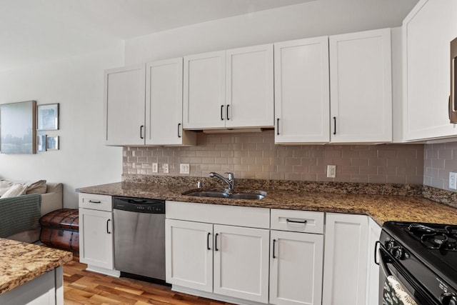 kitchen with stainless steel dishwasher, a sink, and white cabinets