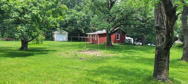 view of yard featuring an outdoor structure and a view of trees