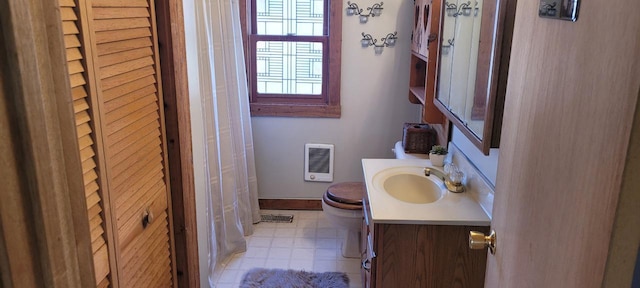 bathroom with visible vents, baseboards, toilet, heating unit, and vanity