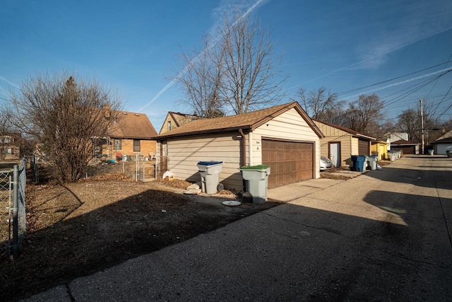 view of side of home featuring fence and a garage