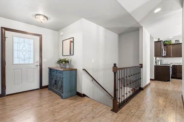 entrance foyer featuring light wood-type flooring and baseboards