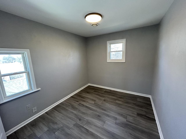 empty room with dark wood-style floors and baseboards