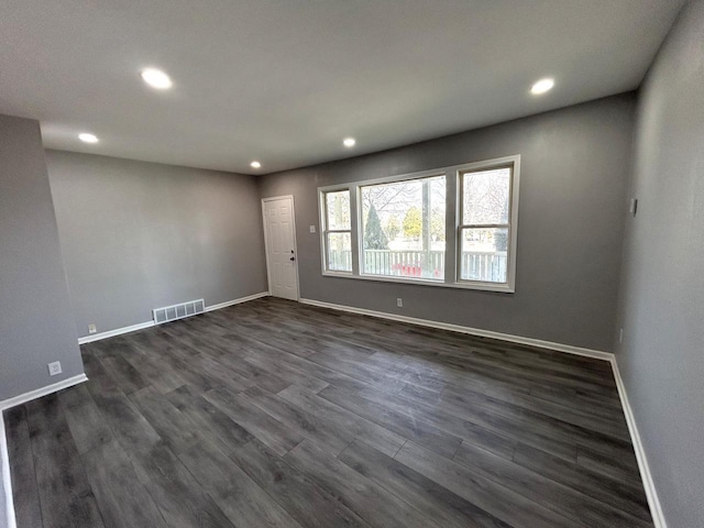 unfurnished room with recessed lighting, visible vents, baseboards, and dark wood-type flooring