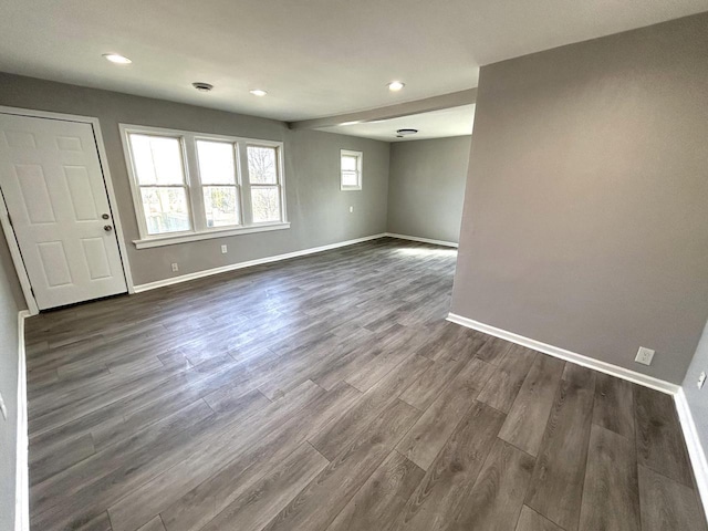 spare room featuring recessed lighting, baseboards, and dark wood-style flooring