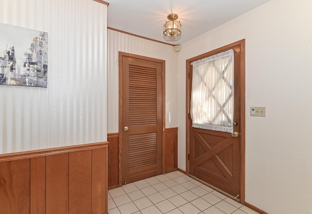 doorway to outside with a wainscoted wall