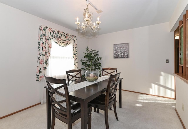 dining room featuring baseboards, light colored carpet, and an inviting chandelier