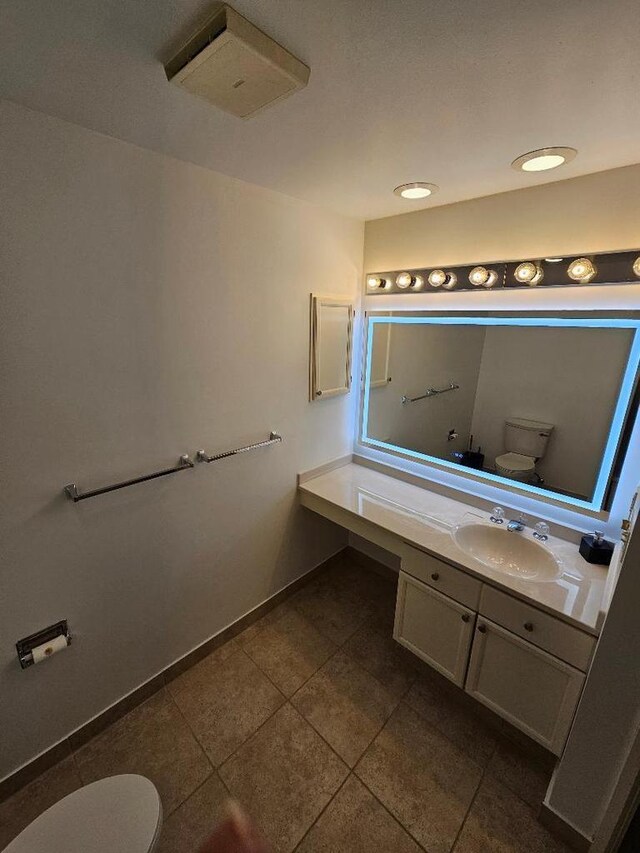 bathroom with tile patterned floors, toilet, vanity, and baseboards