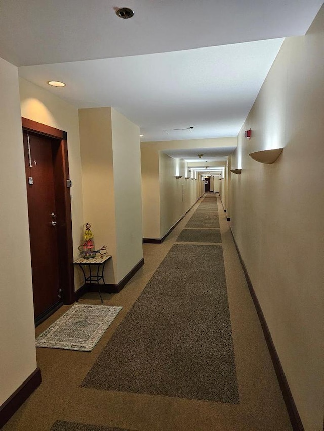 corridor featuring carpet flooring, recessed lighting, and baseboards